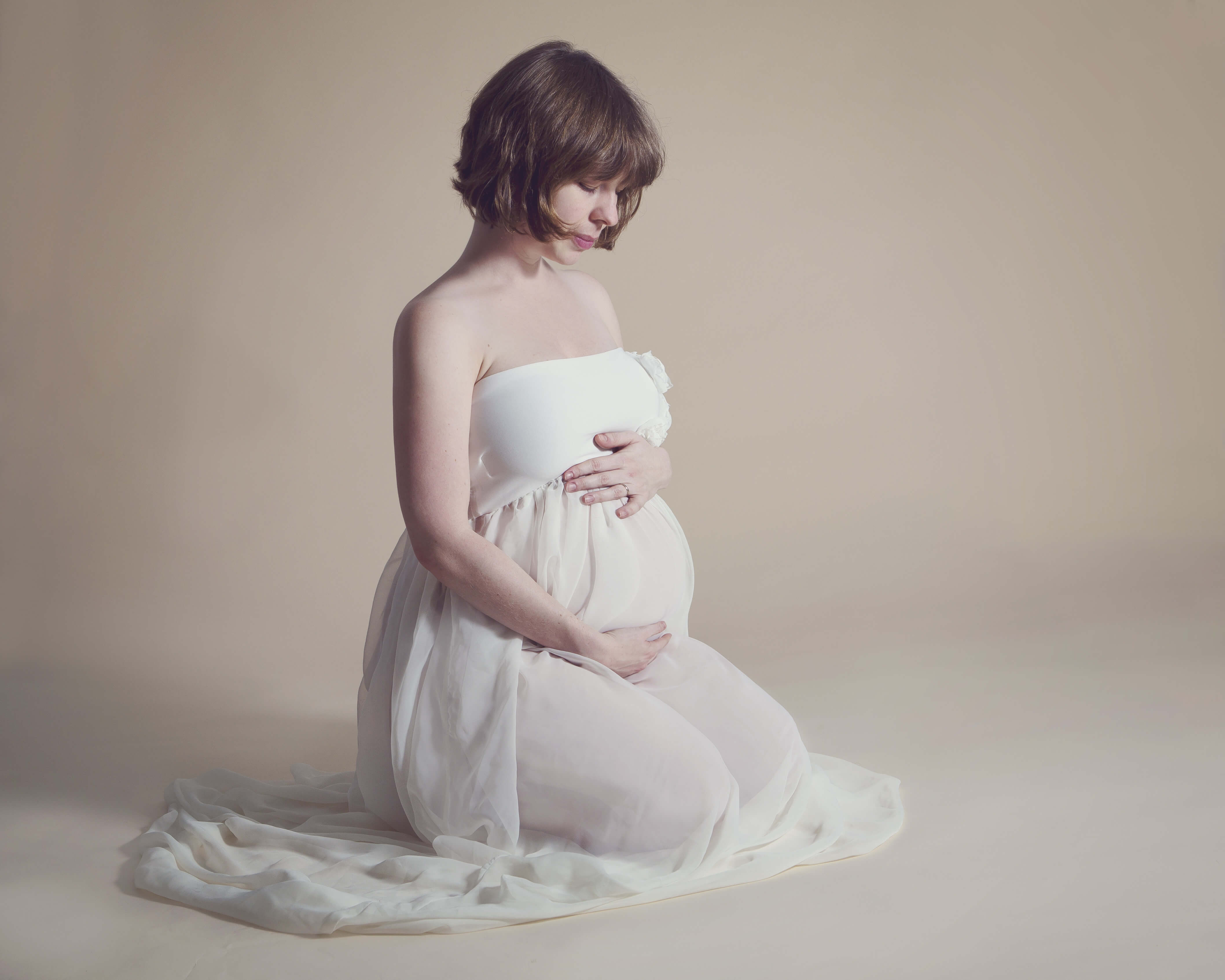 pregnancy photo woman kneeling by Winchester maternity photographer