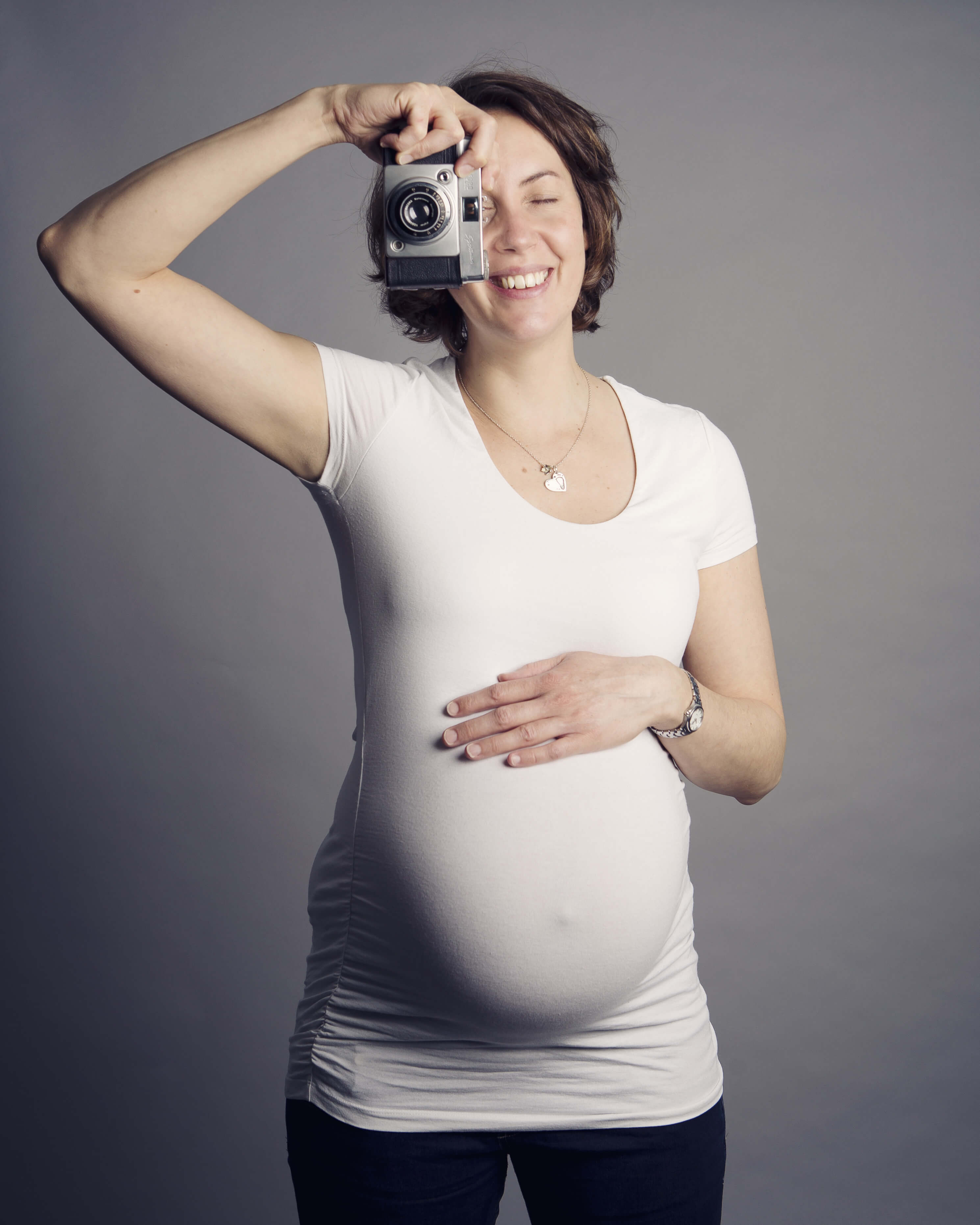 pregnant lady with camera by maternity photographer Winchester