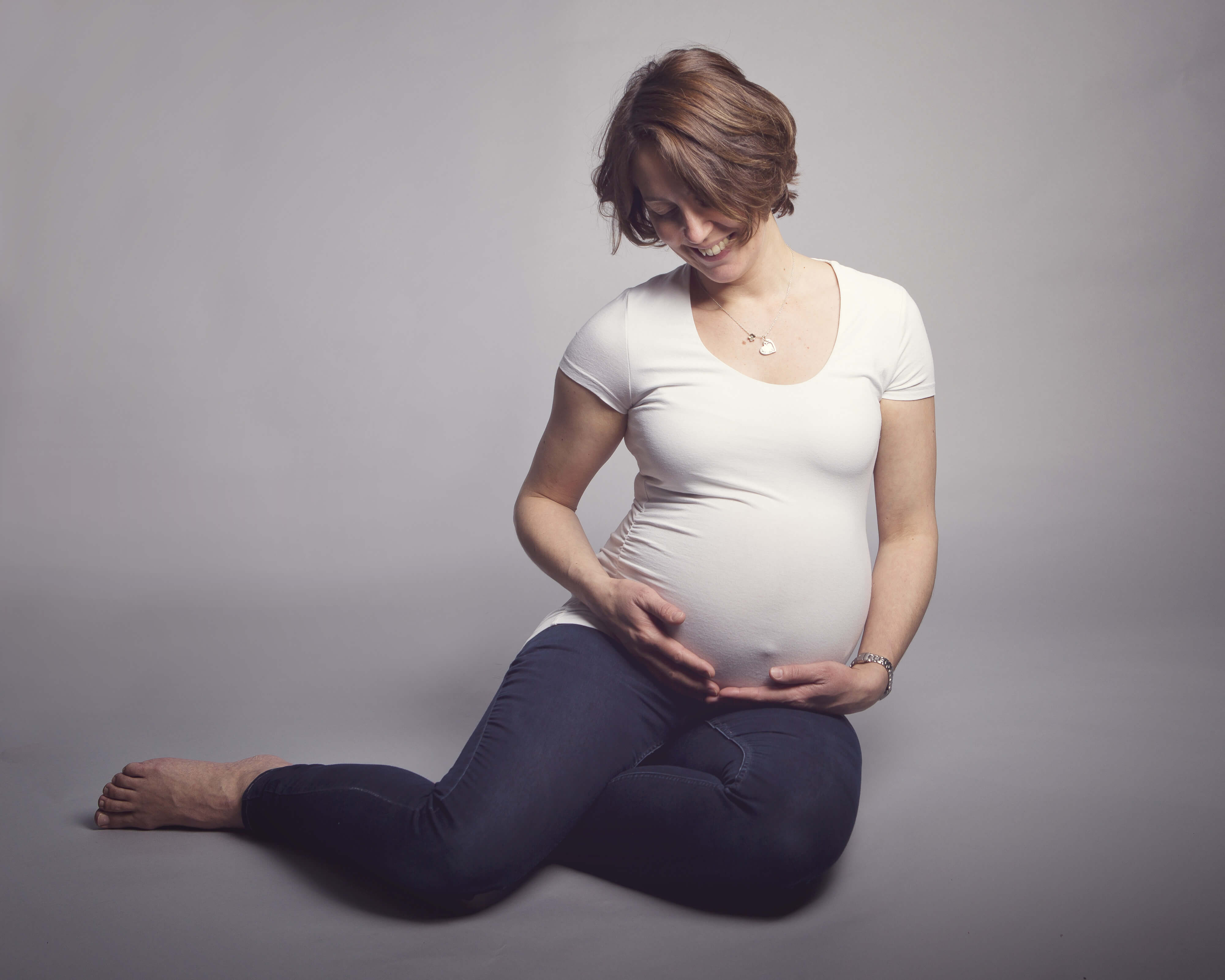 pregnant woman holding bump by Winchester maternity photographer