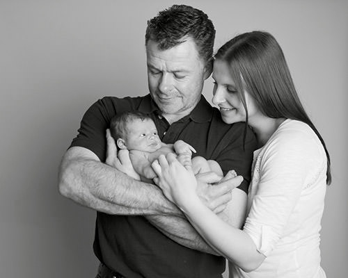Parents cuddling baby by Winchester newborn photographer