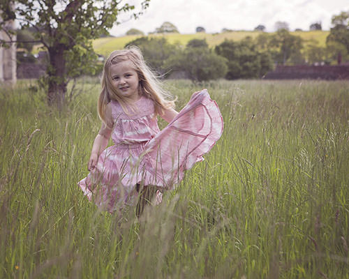 Child in grass by family photographer Winchester 