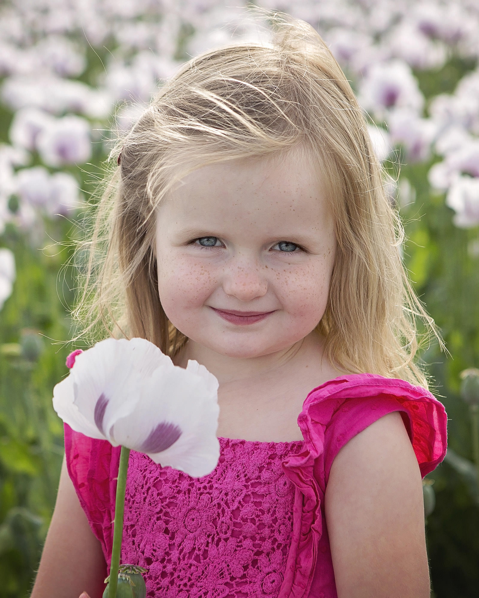 Little girl holding flower by family photographer Hampshire 