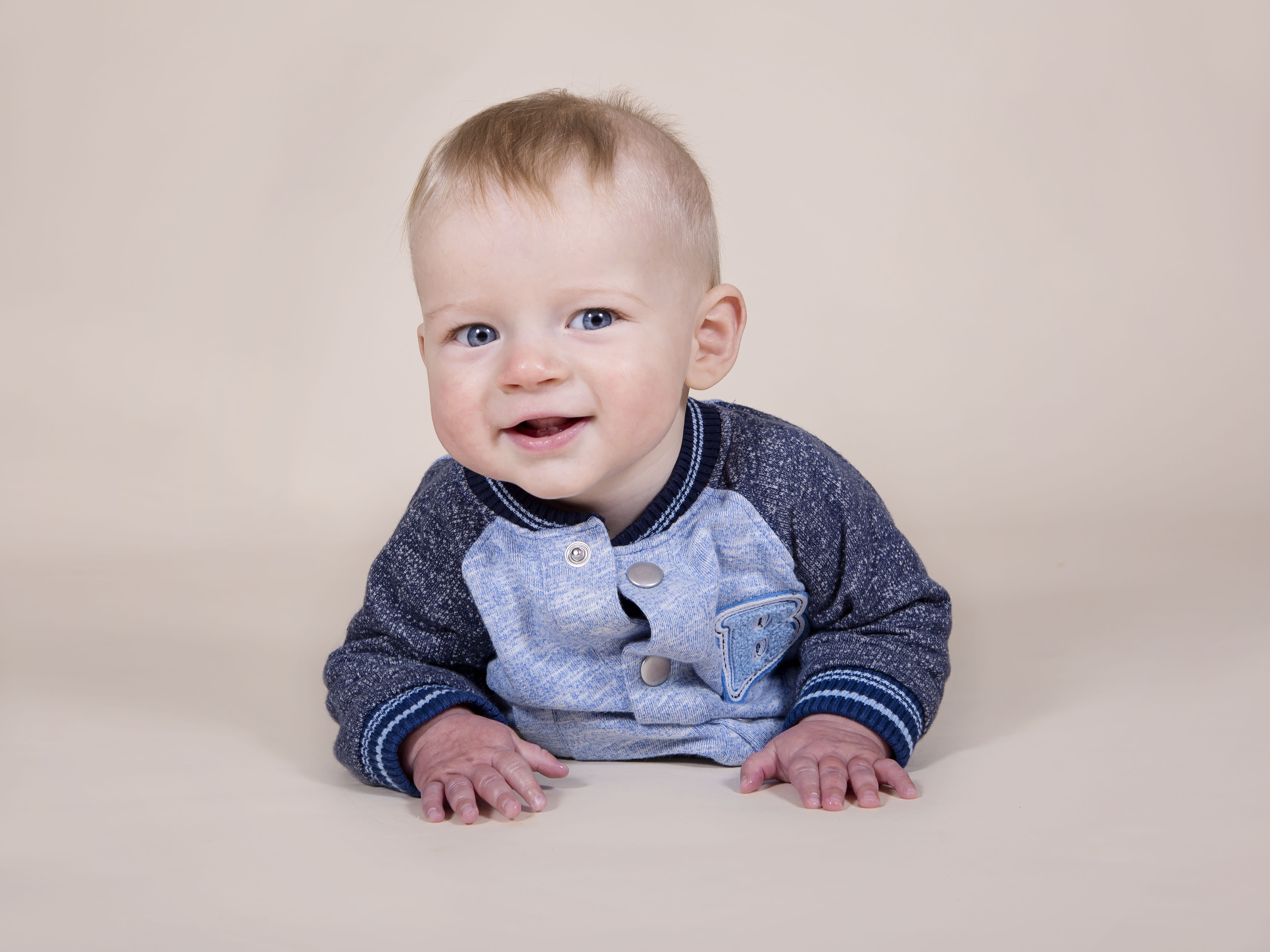 boy lying on his tummy in photography studio by baby photographer Winchester