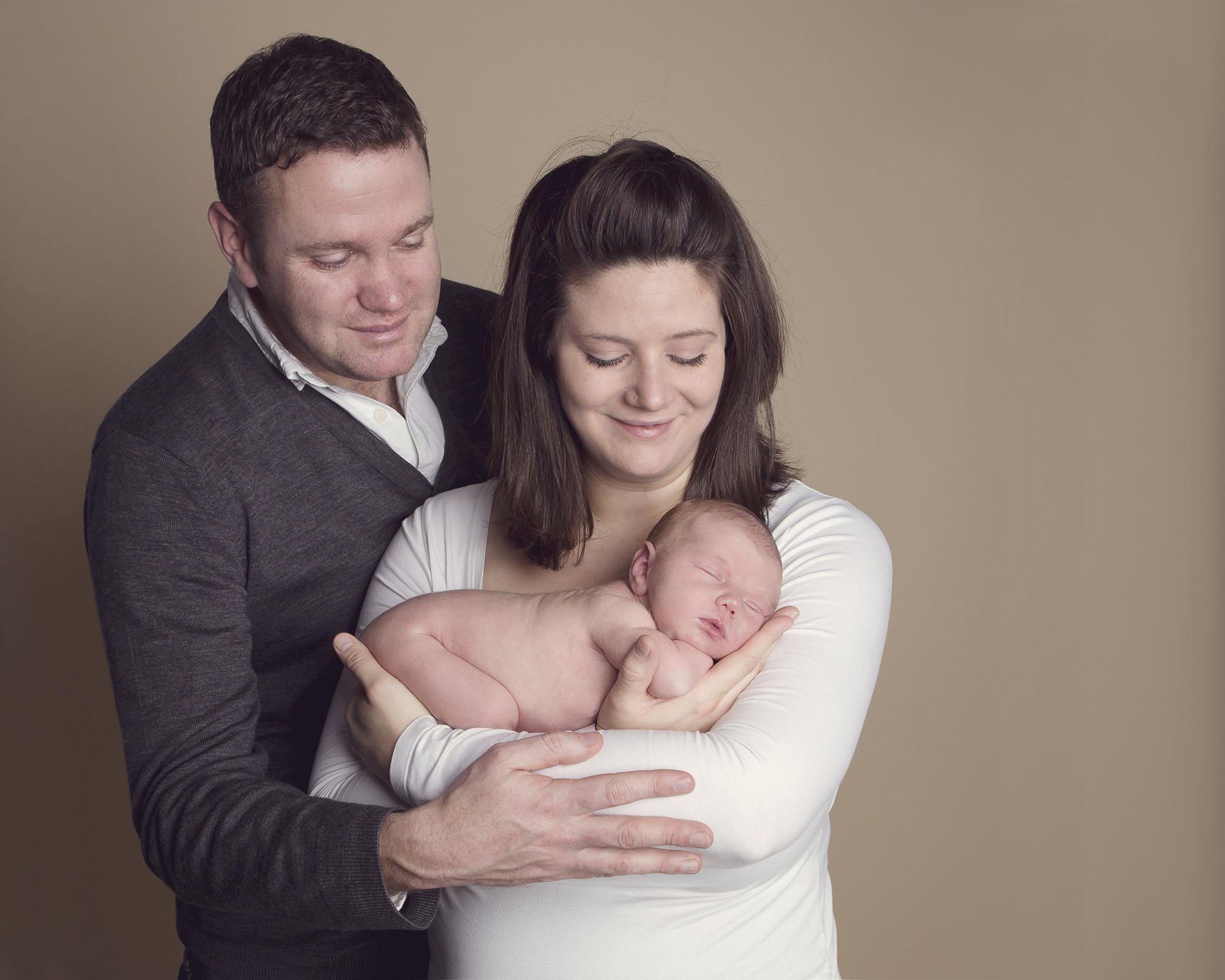 parents cuddling new baby by Winchester newborn photographer