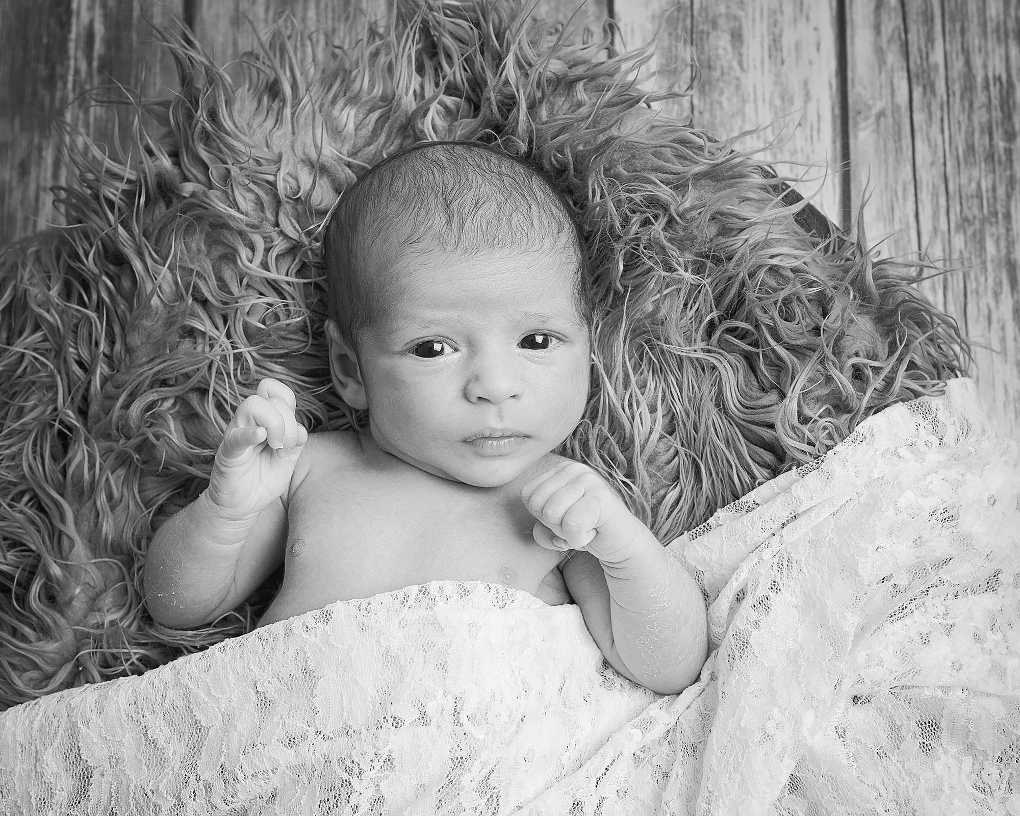 black and white portrait of baby in basket by newborn photographer Winchester