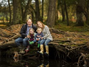 family sitting on tree roots by Winchester family photographer