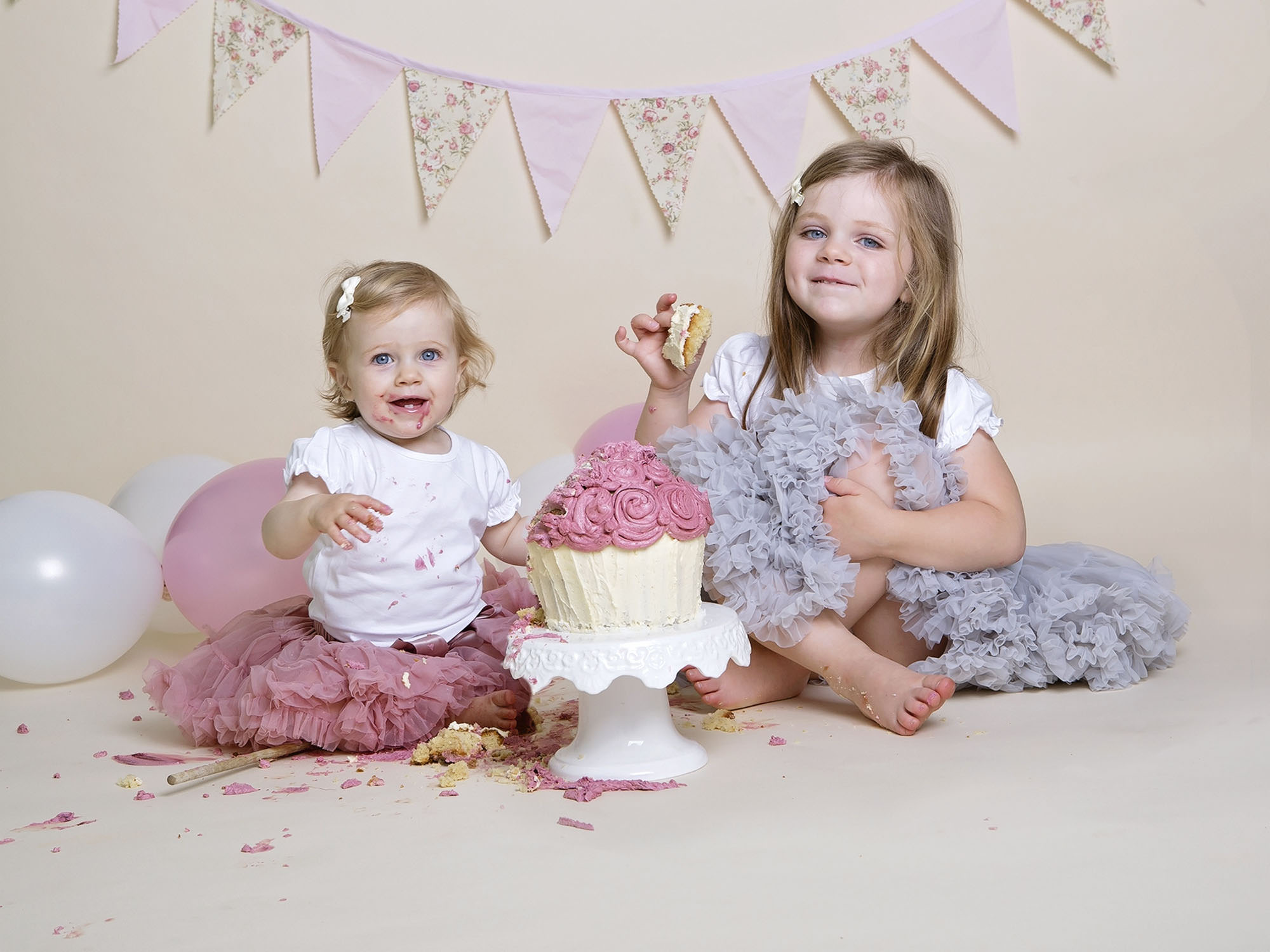 two girls sitting eating cake by cake smash photographer Winchester
