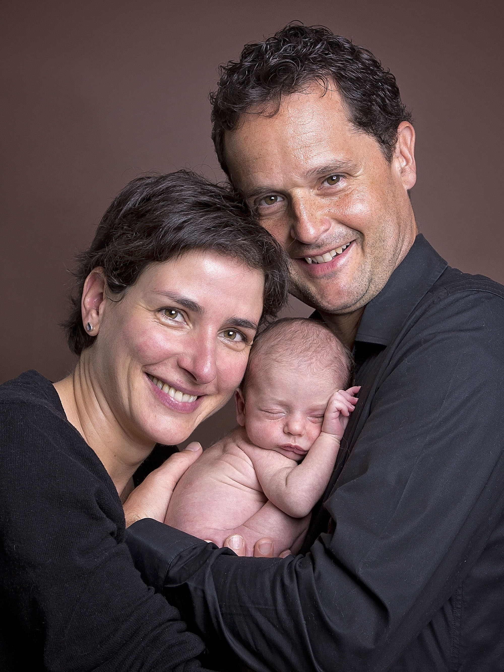 parents cuddling new baby by newborn photographer Winchester