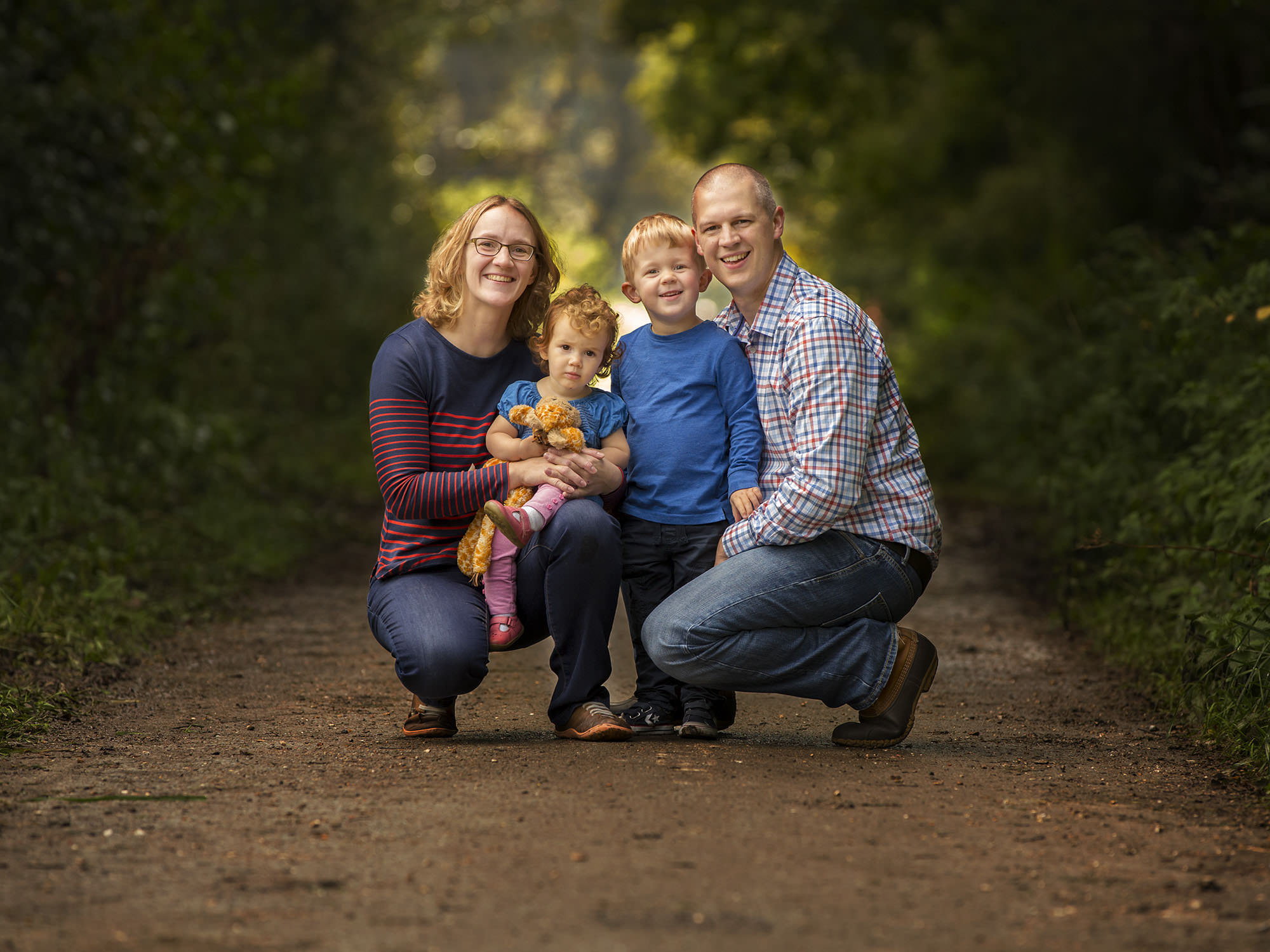 Parents and children in crouching by family photographer Winchester