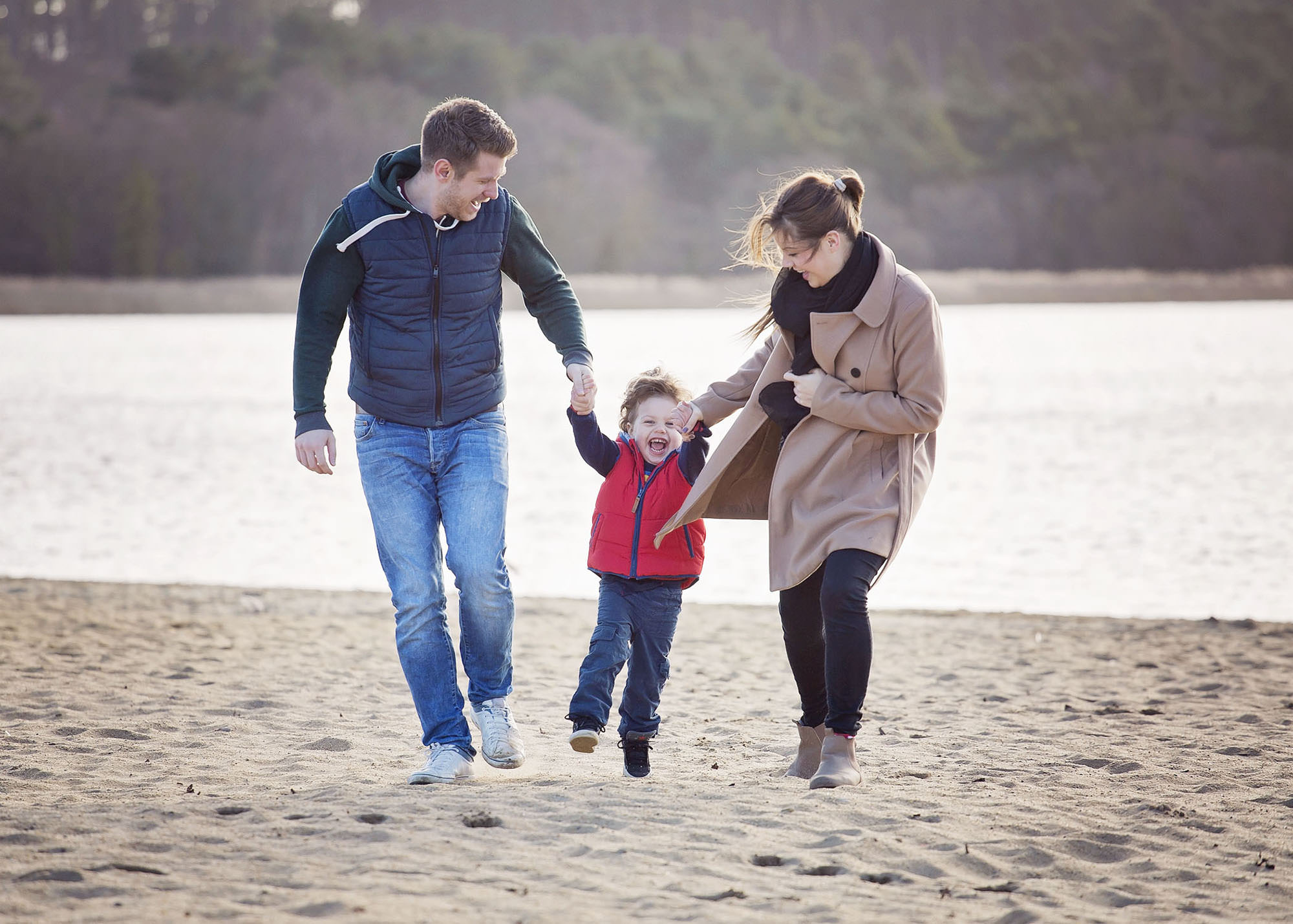 Parents and child at the beach by family photographer Winchester