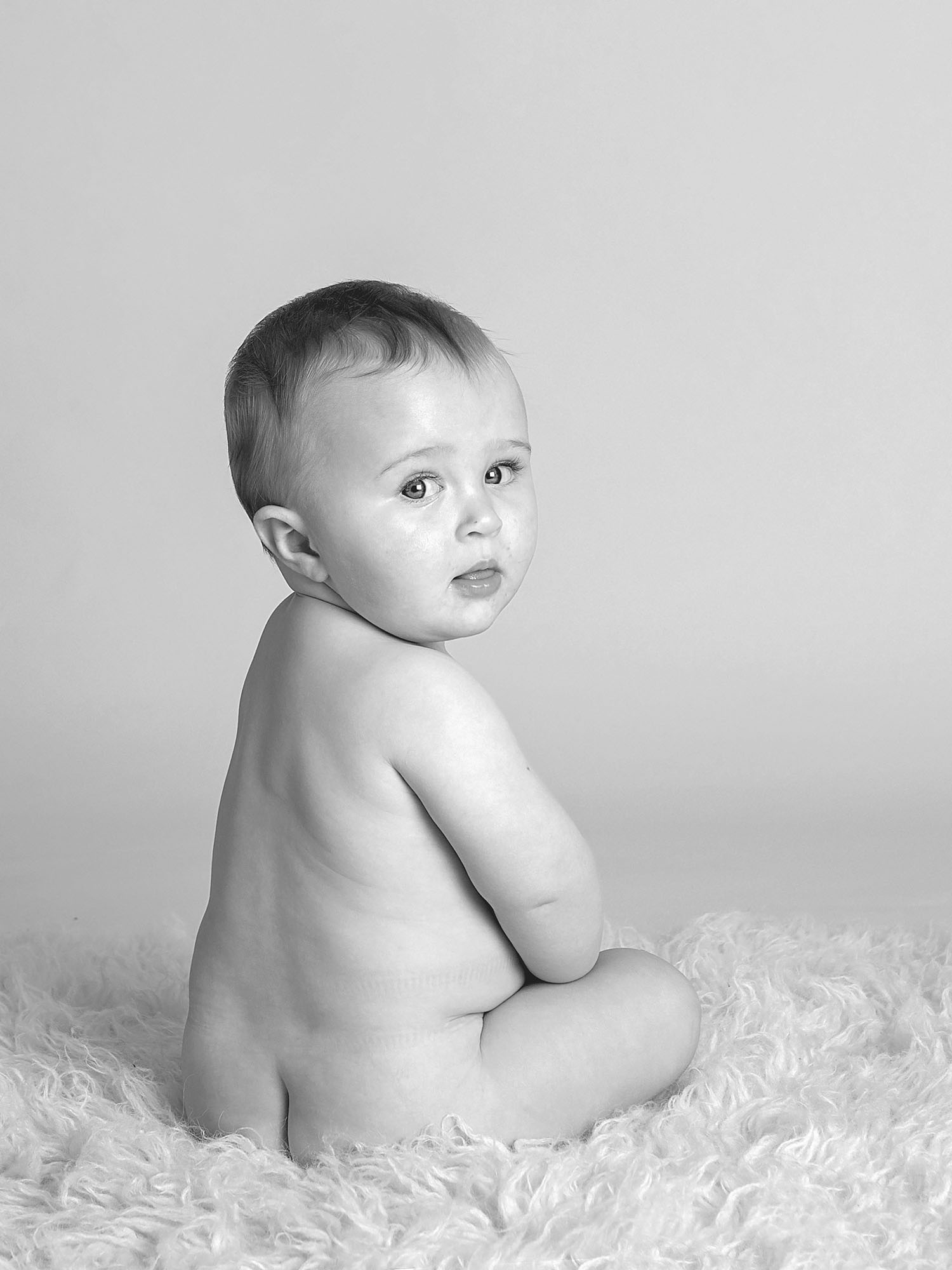 baby looking behind him by baby photographer Winchester