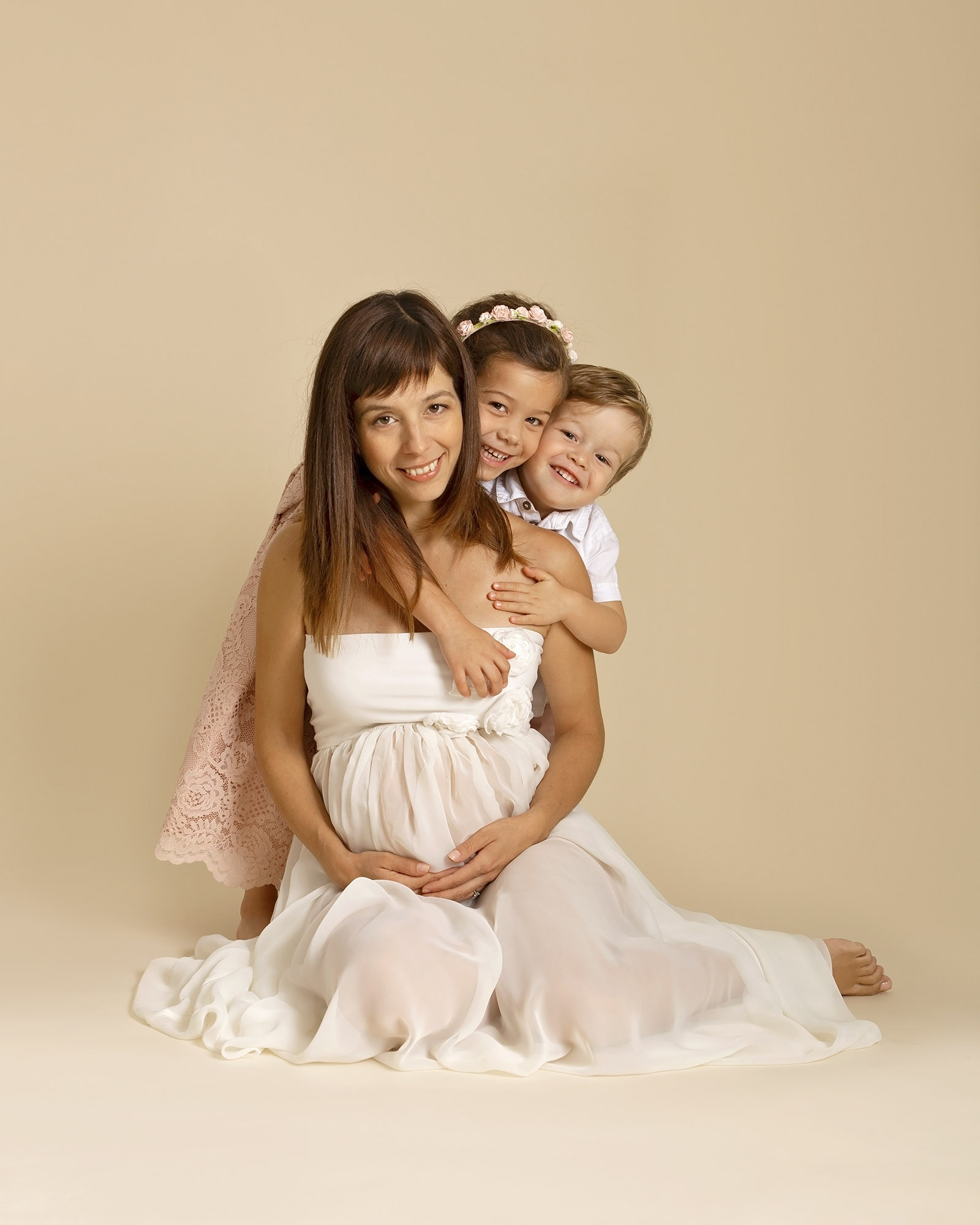 pregnant woman cuddling her children by maternity photographer Hampshire