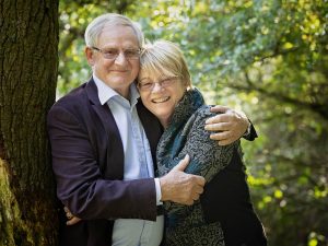 retired couple hugging by family photographer Hampshire