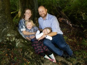 family laughing in the woods by family photographer Winchester, Hampshire