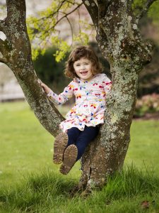 girl sitting in a tree in Hampshire