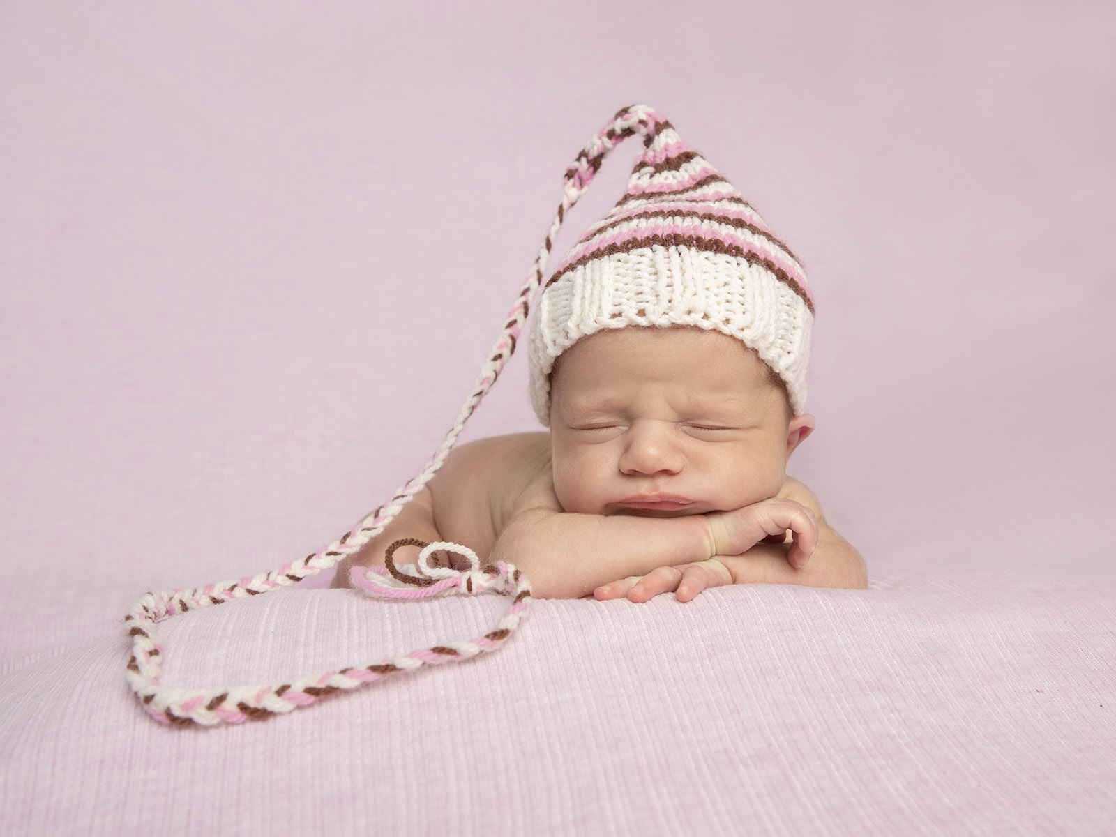 Sleeping newborn with striped hat by newborn photographer Winchester