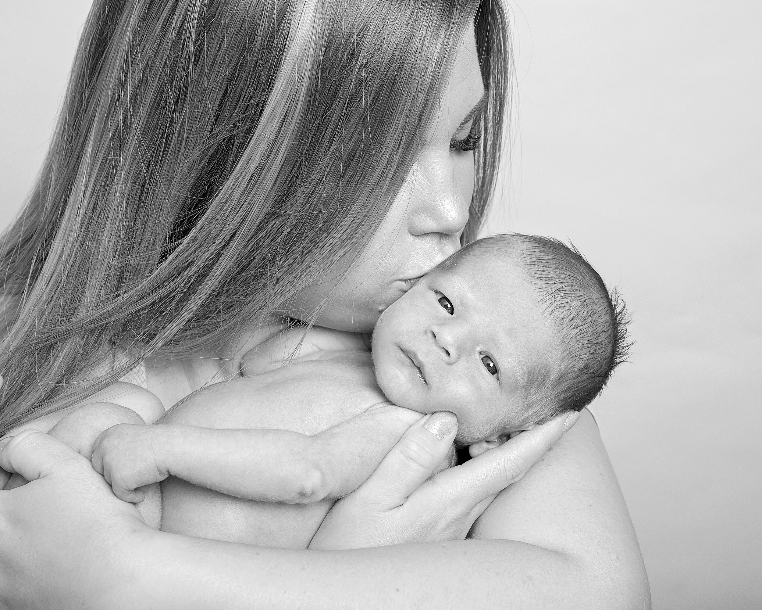 mum kissing new baby by Winchester newborn photographer