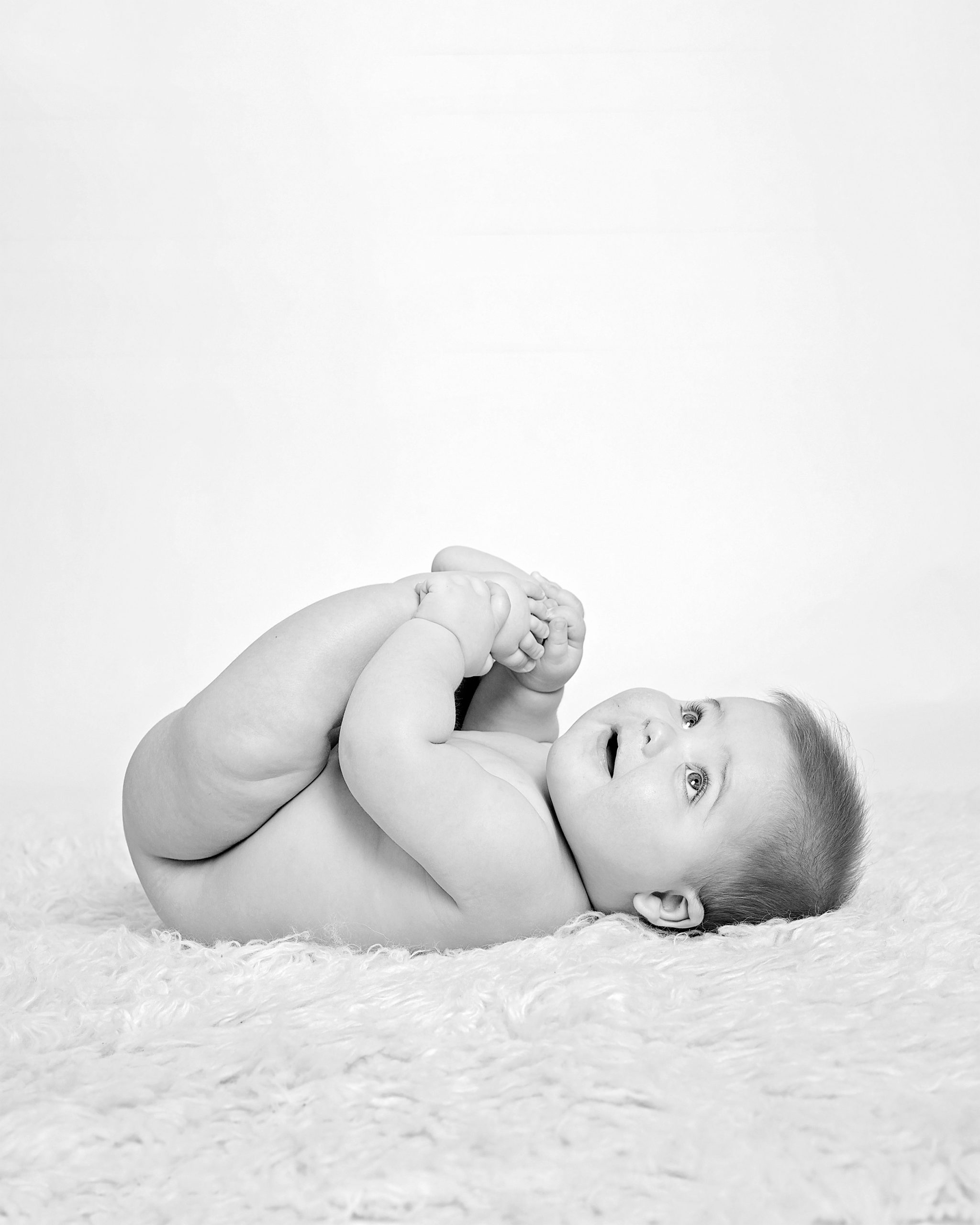six month baby lying on her back by Hampshire family photographer